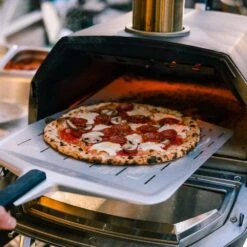 Ooni Karu 16 Inch Portable Wood And Charcoal Fired Outdoor Pizza Oven Loaded Bundle -Joes BBQs Store Ooni Karu 16 in use e 1024x1024 2x 5ad77d0c 209b 4d3a be46 ff07e6d5de3c 1