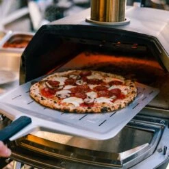 Ooni Karu 16 Inch Portable Wood And Charcoal Fired Outdoor Pizza Oven Startup Bundle -Joes BBQs Store Ooni Karu 16 in use e 1024x1024 2x 5ad77d0c 209b 4d3a be46 ff07e6d5de3c